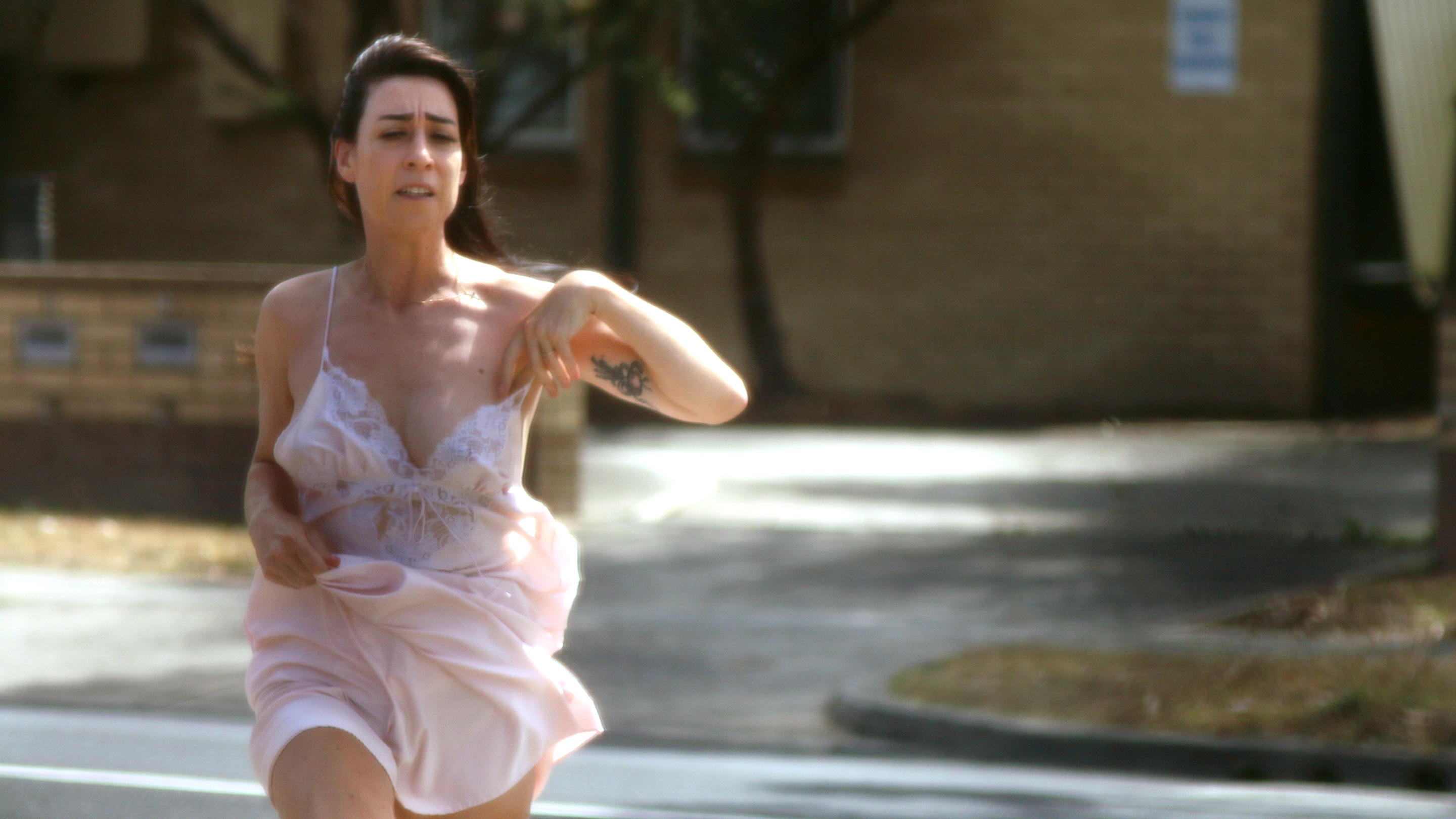 Sarah Mary Chadwick runs down a suburban street in a night dress in the daytime