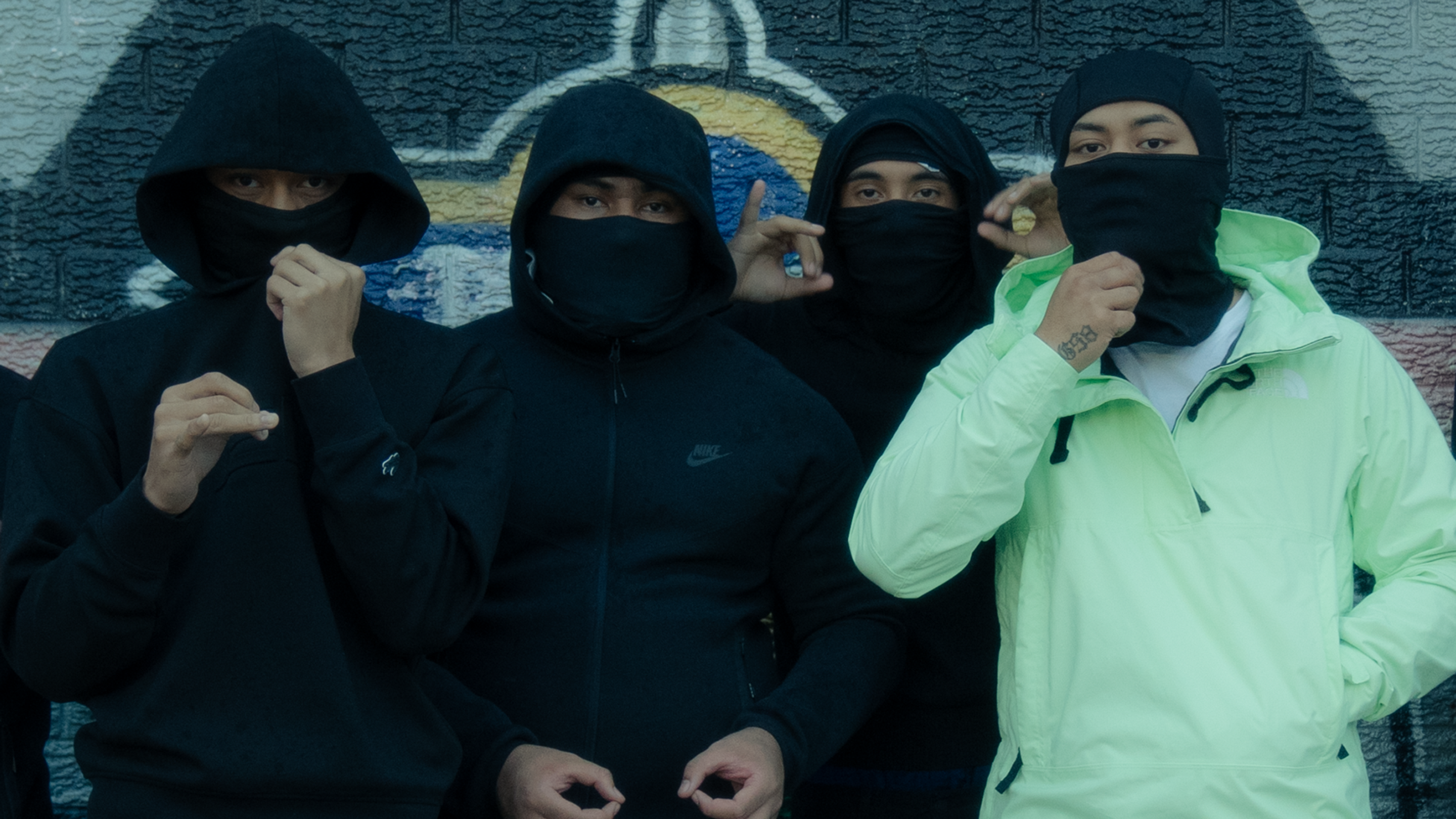 Four members of RFA17 wearing balaclavas over the faces and hoodies