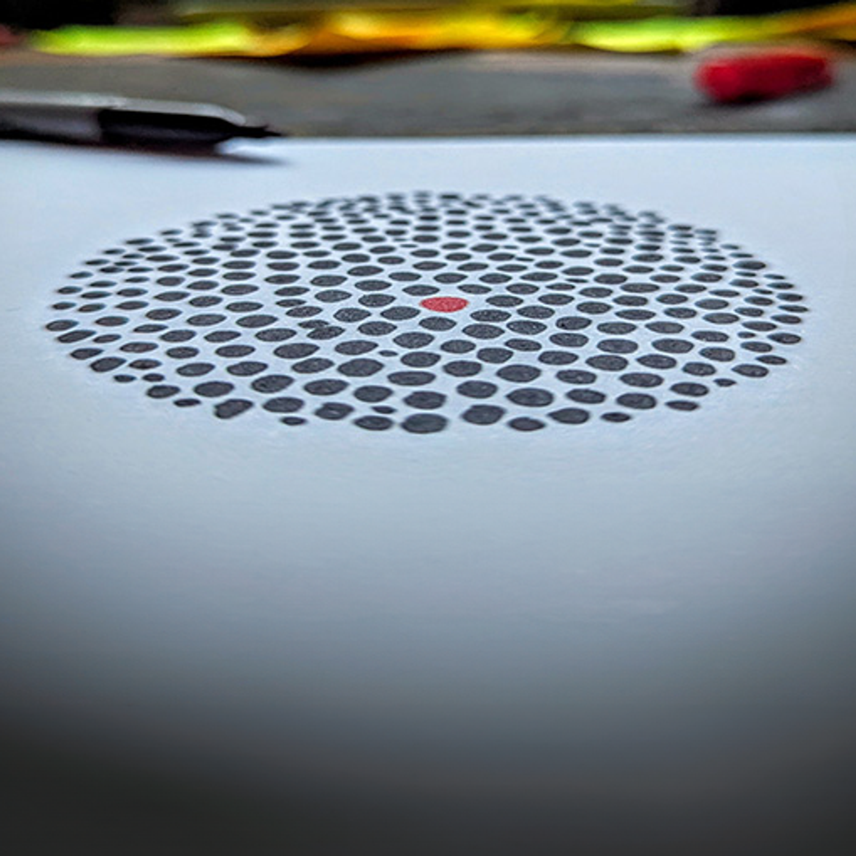 An abstract drawn image of dots on paper in a circle 