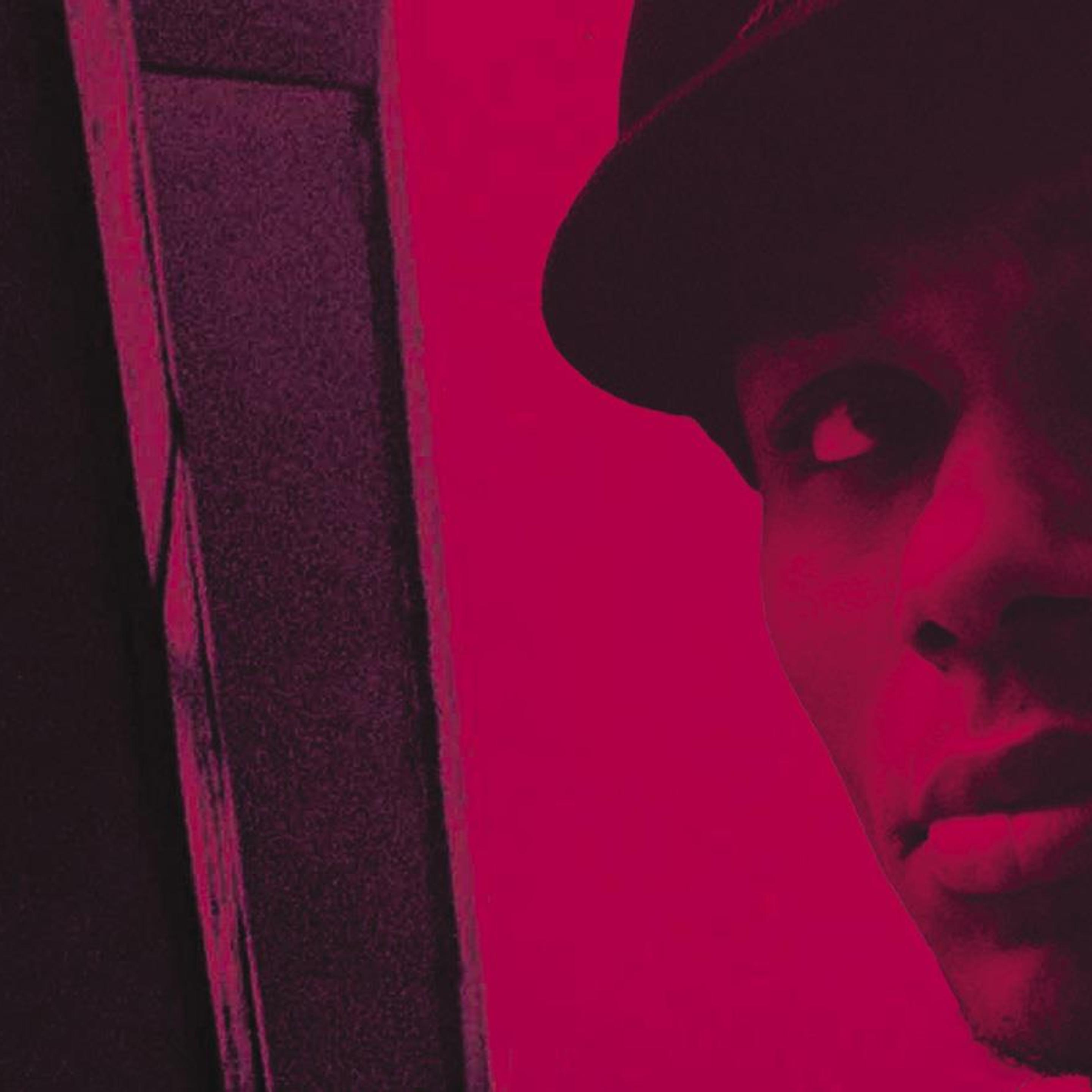A headshot of Yasiin Bey wearing a hat and looking upwards